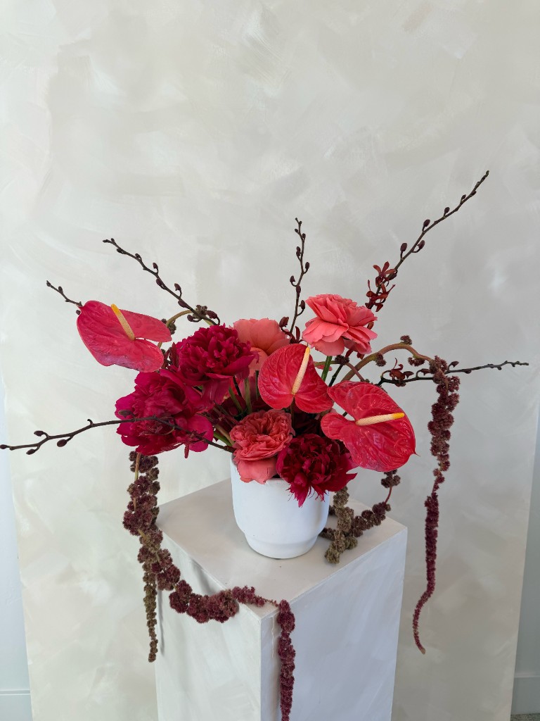 Lush floral arrangement with anthuriums, roses and cascading amaranthus